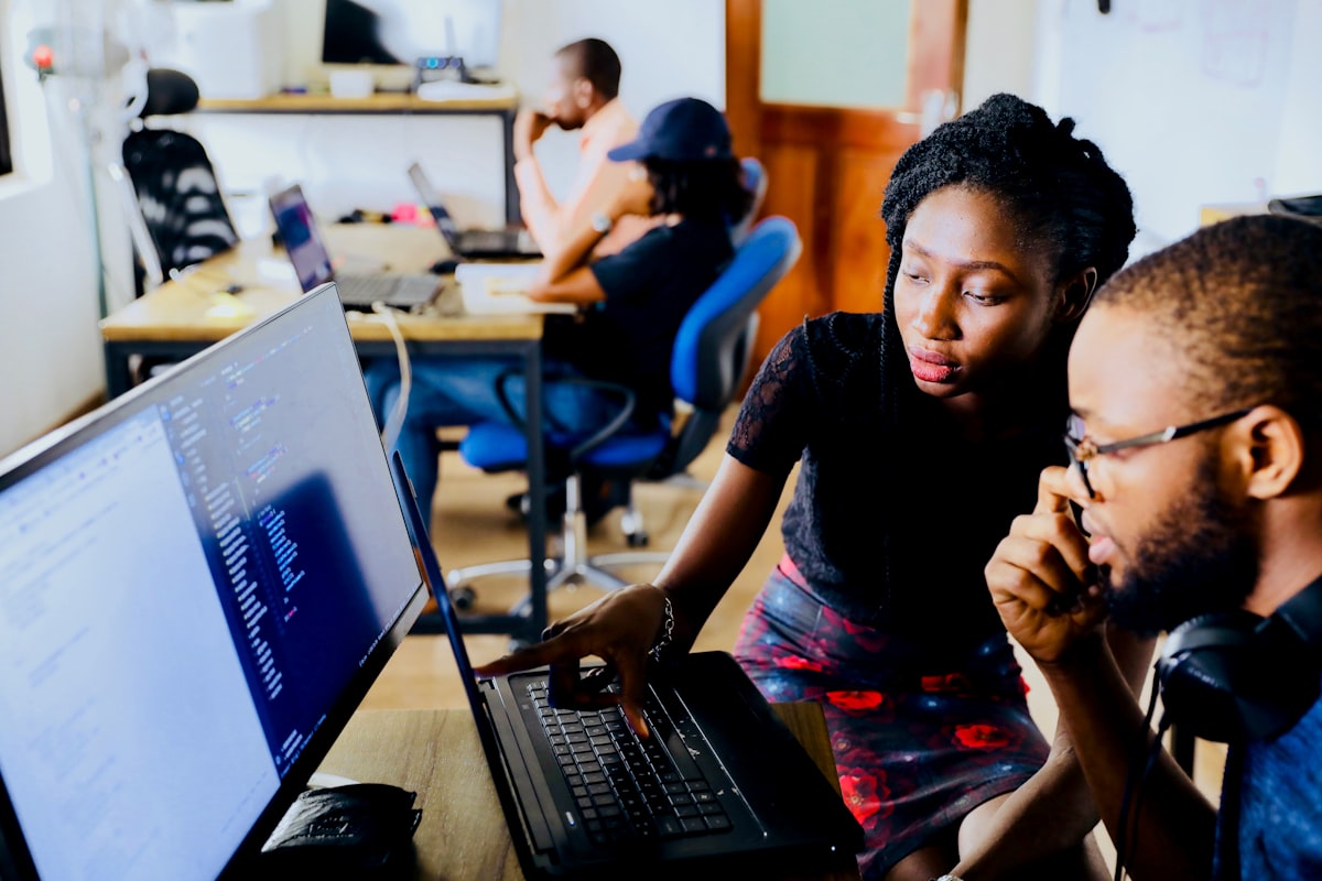 Proprietor and school administrator managing student attendance and fees on laptop